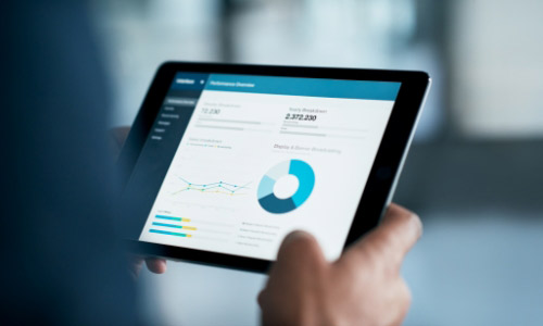 Hand holding ipade with data graphs